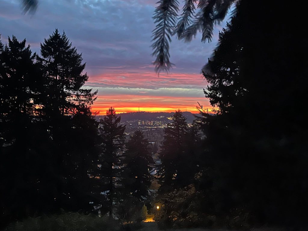Colorful November sunset over Portland viewed from Mt. Tabor Park, with city lights below.